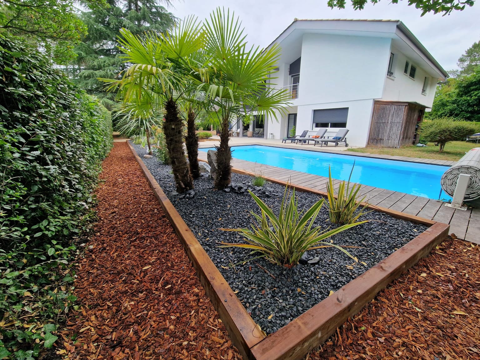 Jardin exotique avec palmiers au bord de la piscine, aménagement paysager près de Bordeaux